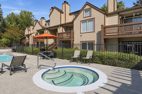 A pool with a hot tub in front of a house.
