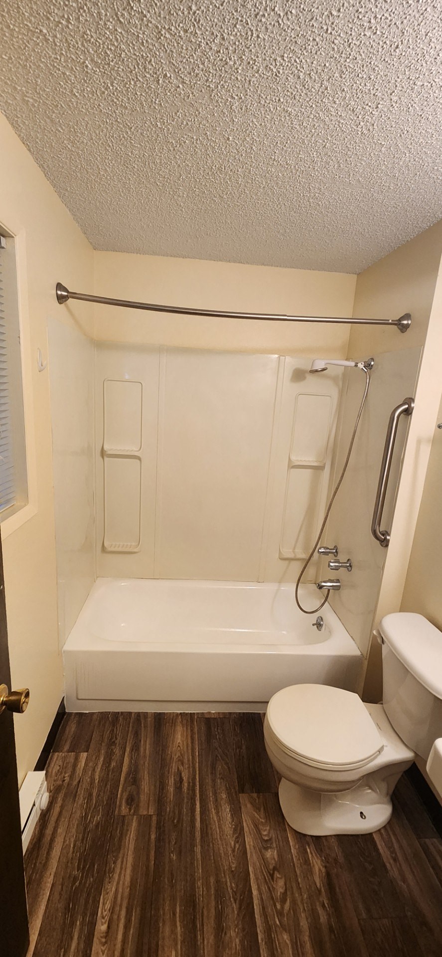 Nell Anna Court white toilet sits next to a white bathtub in a bathroom.