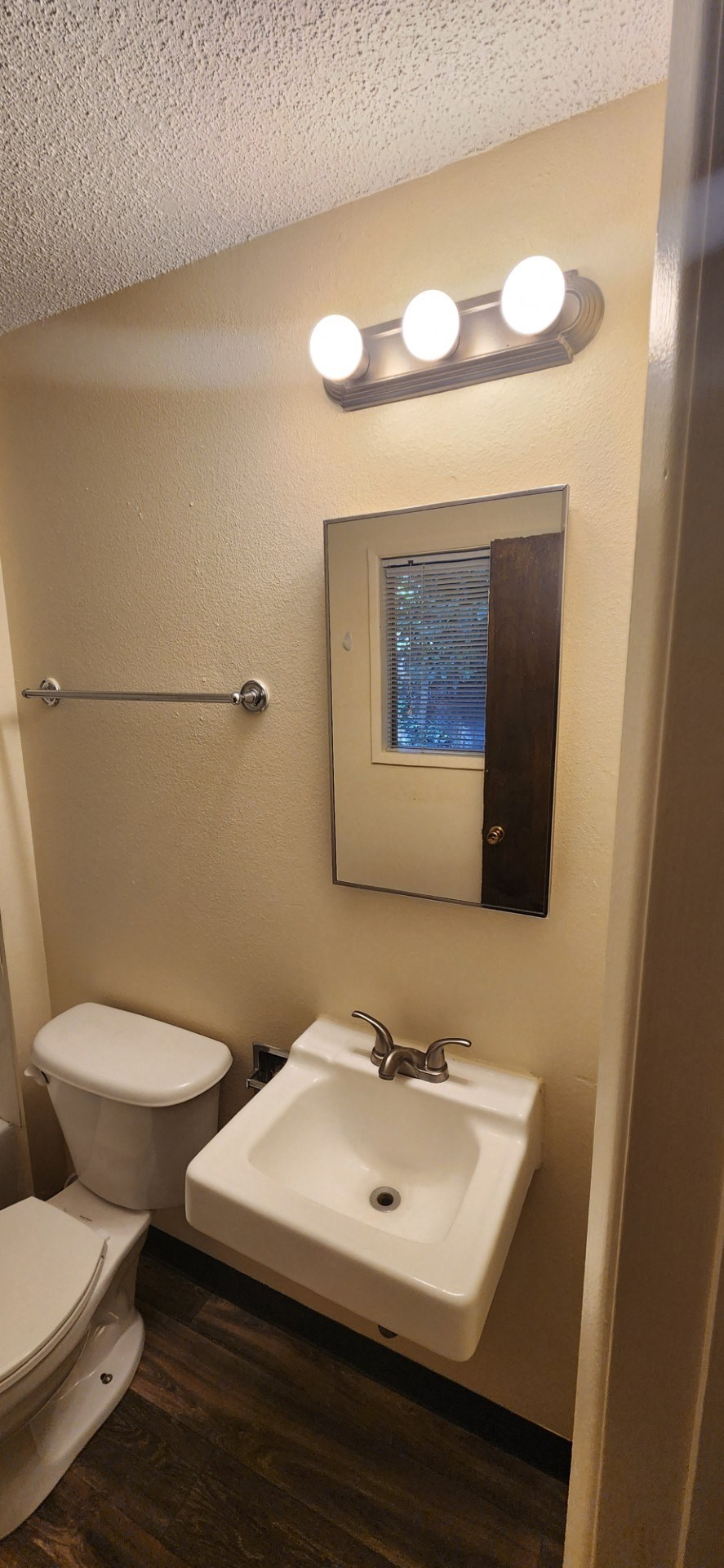 Nell Anna Court bathroom with a toilet, sink and mirror.