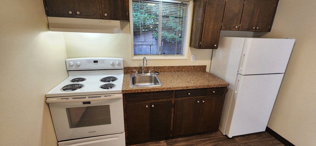 Nell Anna Court kitchen with brown cabinets and a white fridge.