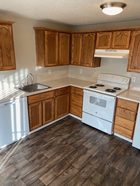 A kitchen with wooden cabinets and a white stove top oven.