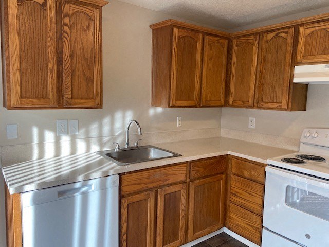 A kitchen with wooden cabinets and a white stove.