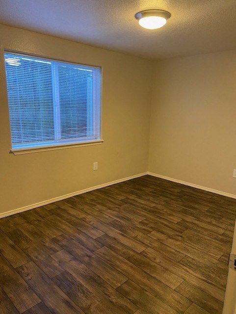 A room with a window and wooden flooring.