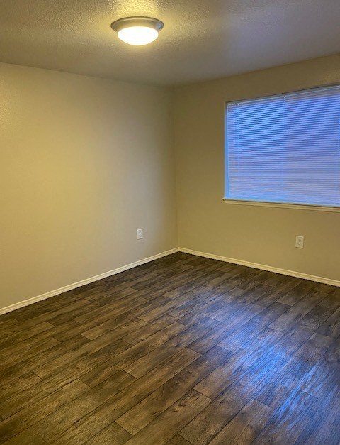 A room with a window and wooden flooring.