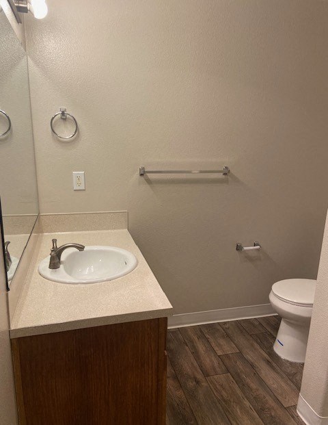 A bathroom with a toilet, sink, and mirror.