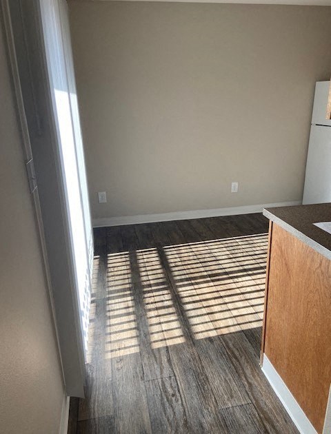 A kitchen with a white refrigerator and wooden cabinets.