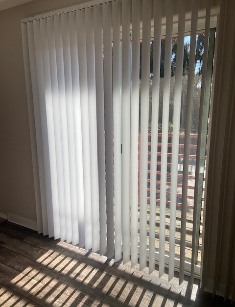 A white blind is open and letting light into a room.