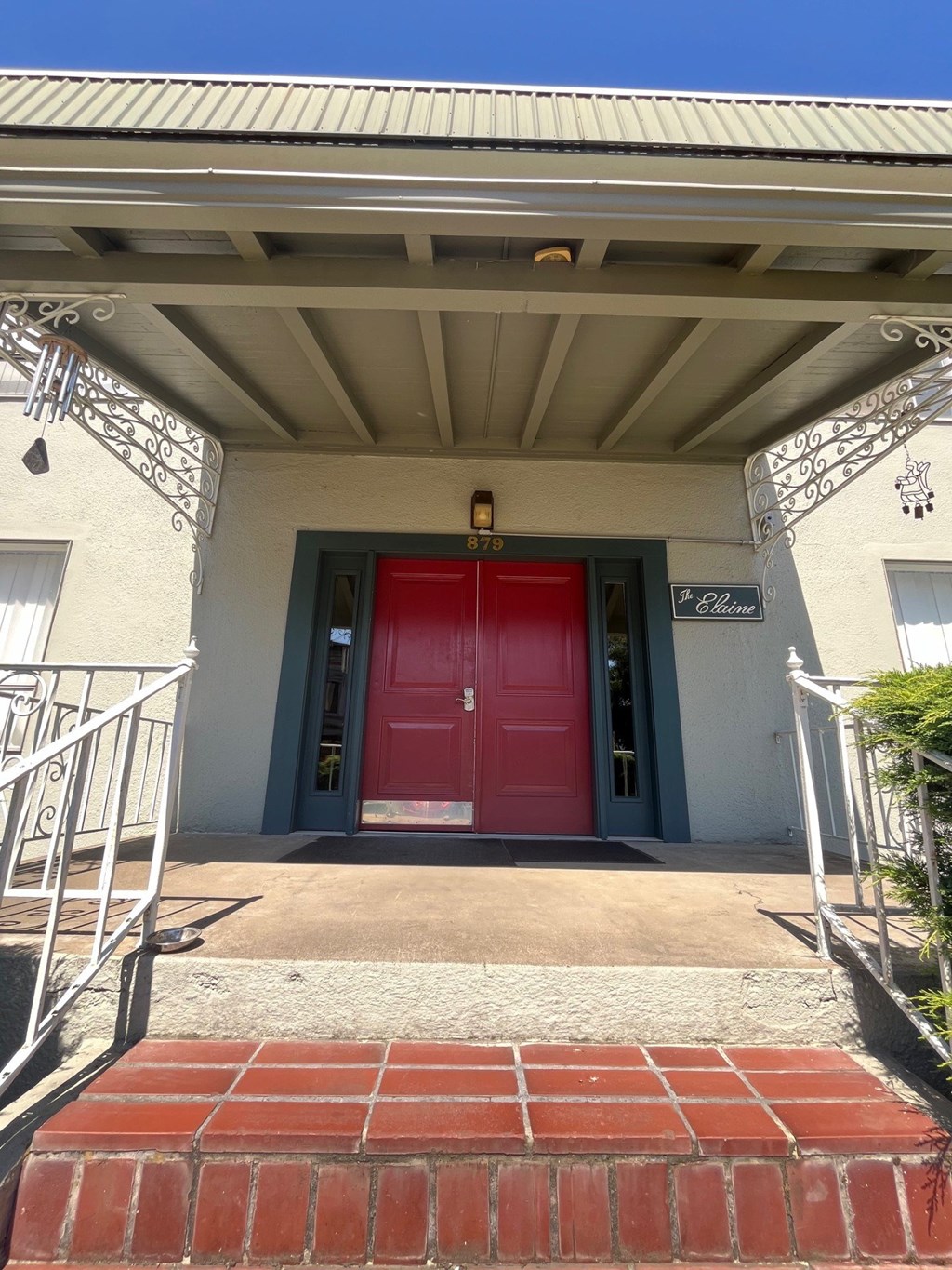 A red door is on the front of a white building.