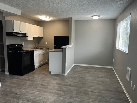 A kitchen with a black stove top oven and white cabinets.