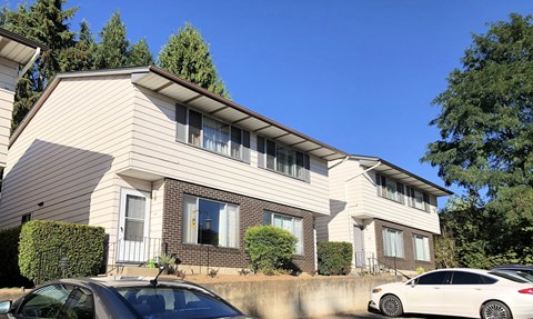 A white car is parked in front of a house.