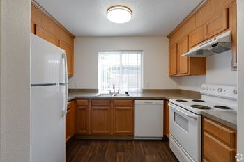 A kitchen with white appliances and wooden cabinets.