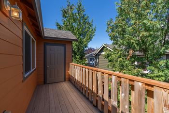 A wooden deck with a brown door and a window.