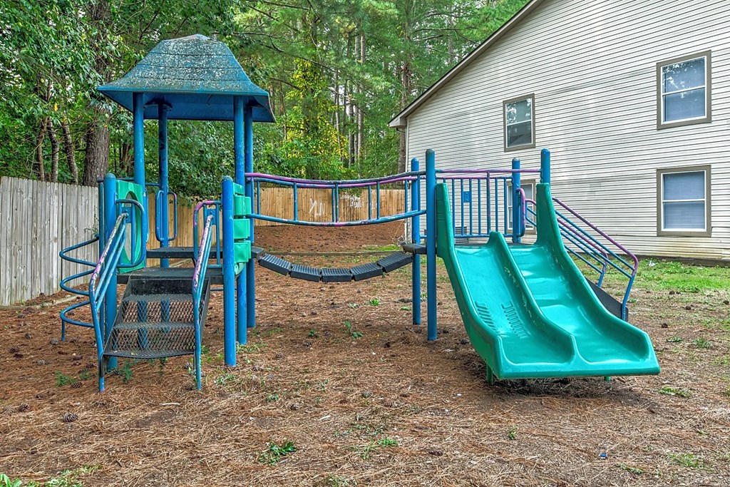 a playground with two slides and a swing set