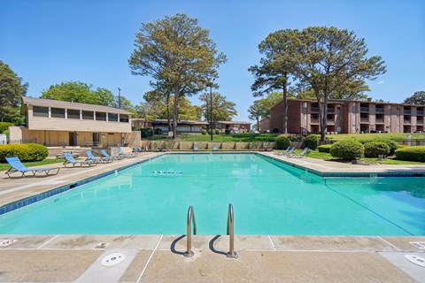 A large swimming pool with a diving board in the middle of it.