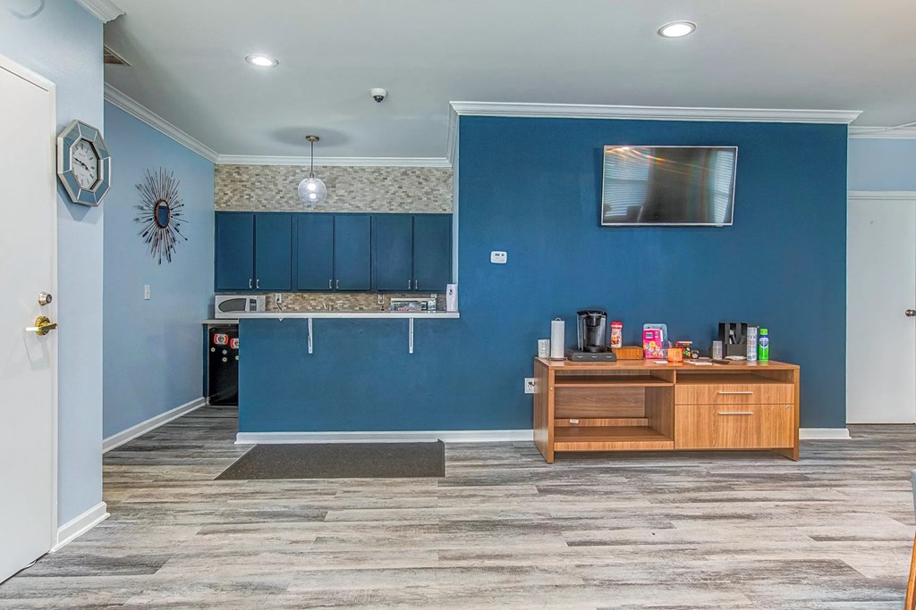a living room with a blue wall and a wooden cabinet