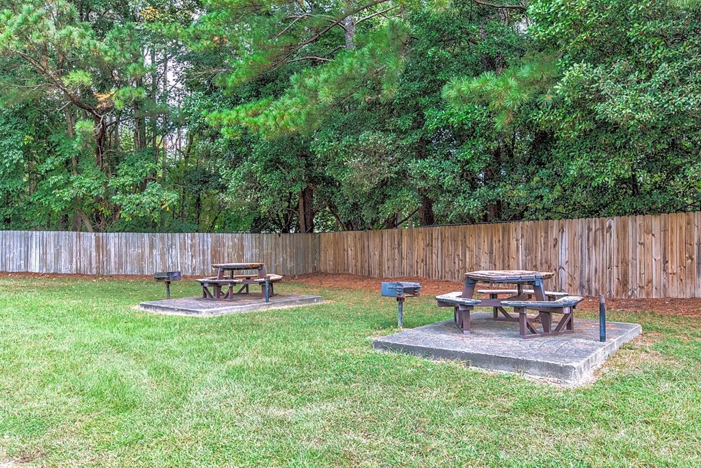 three picnic tables sitting in the grass in a backyard