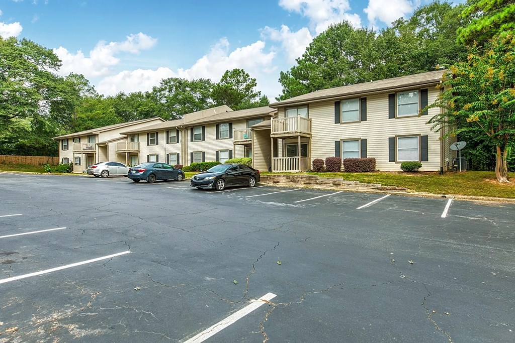 an empty parking lot in front of an apartment building