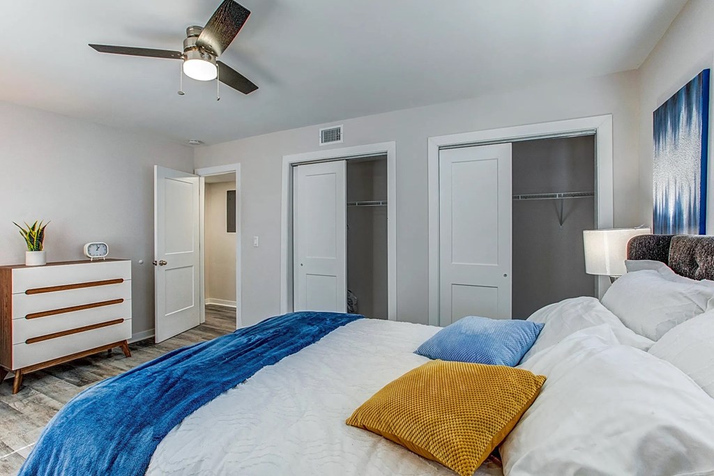 a bedroom with a large bed and a ceiling fan
