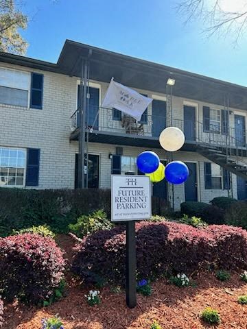 a sign in front of a building with balloons