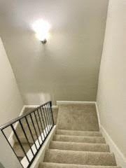 a staircase with a rail and a light on the ceiling