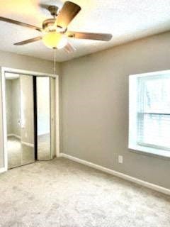an empty bedroom with a ceiling fan and a window