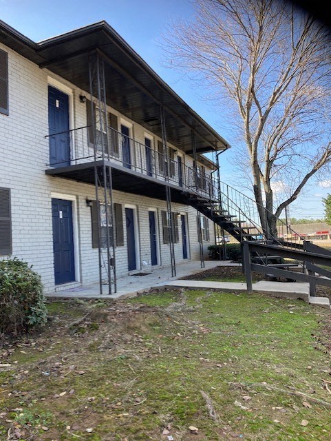 a building with a staircase and a tree in front of it