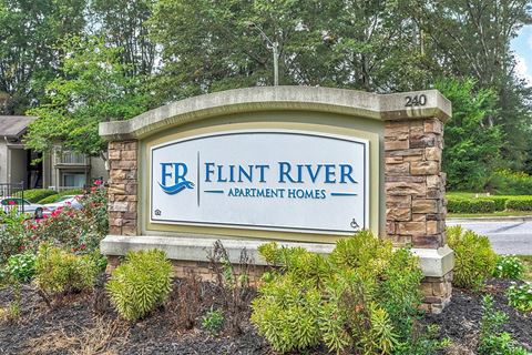 a stone monument sign for flint river apartments