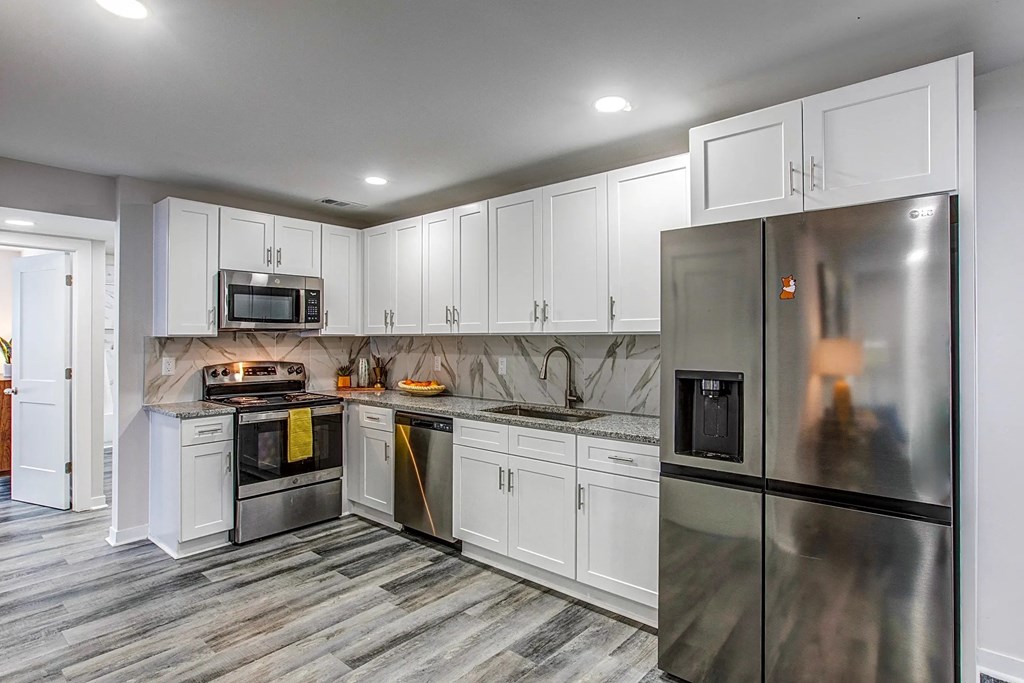 a kitchen with stainless steel appliances and white cabinets