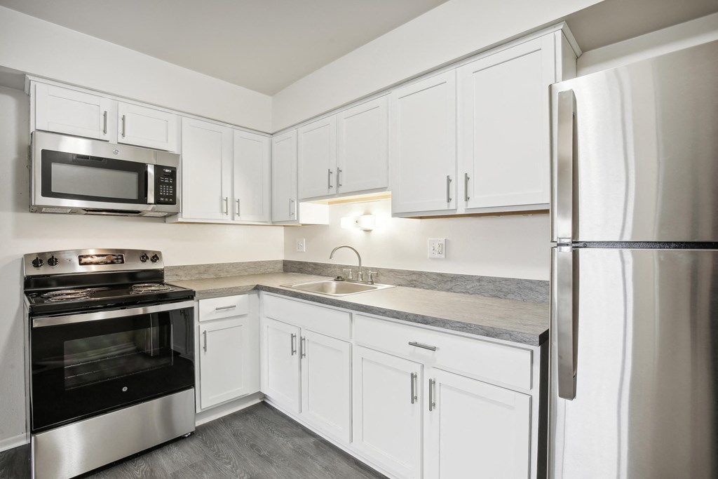 A kitchen with white cabinets and stainless steel appliances.