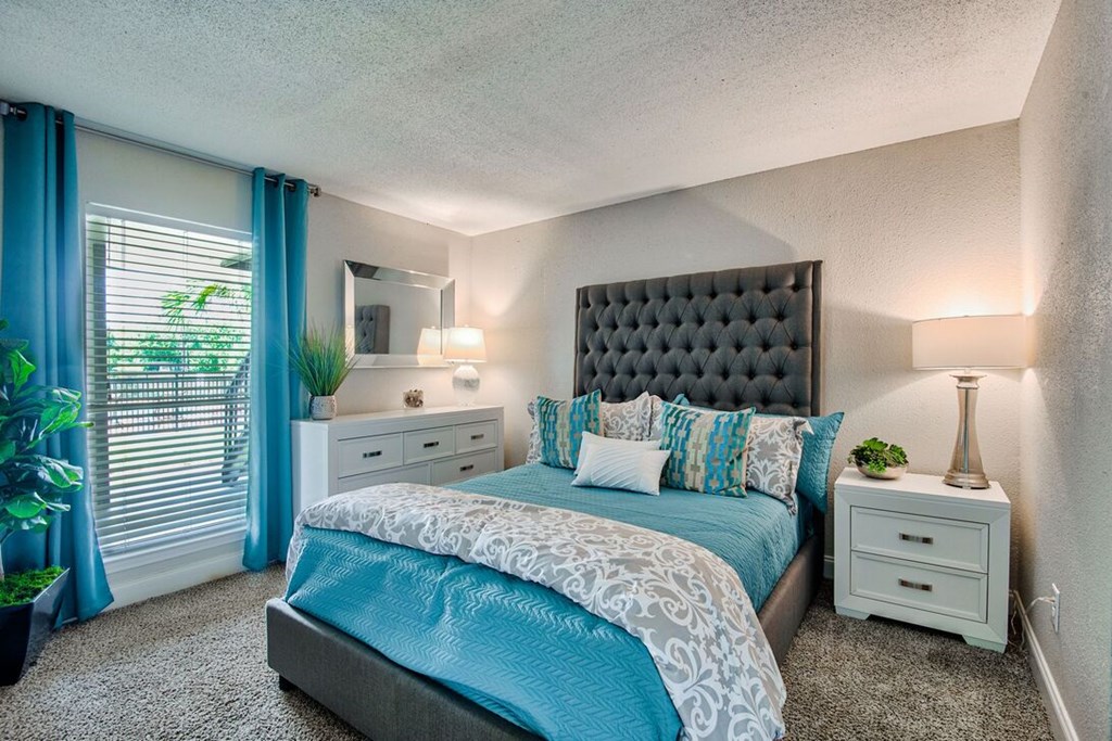 A bedroom with a large bed and a mirror on the wall.