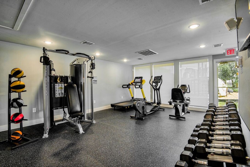 A gym with a variety of equipment including weights, a treadmill, and a stationary bike.