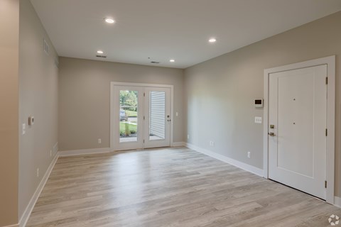 A spacious room with a sliding glass door leading to a patio.