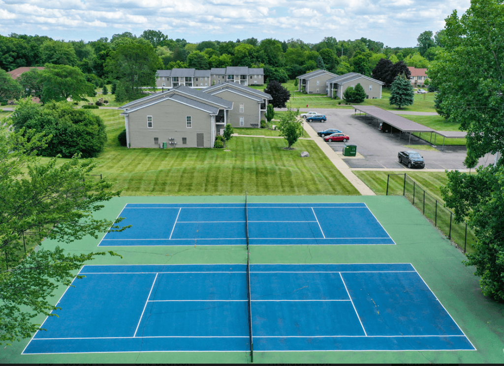 an aerial view of a tennis court with houses in the background