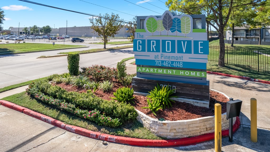 A sign for The Grove apartment homes sits in front of a landscaped area.