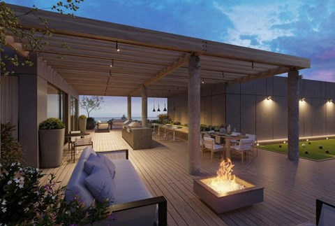 A modern outdoor patio area with a fire pit and seating.
