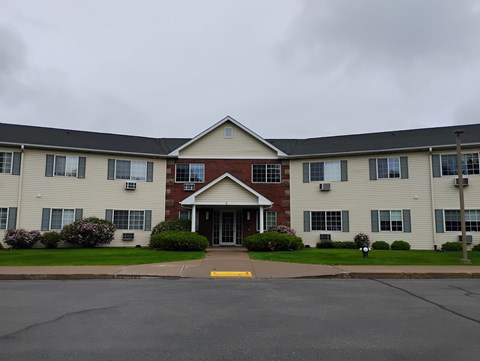 A large apartment complex with a red brick entrance.