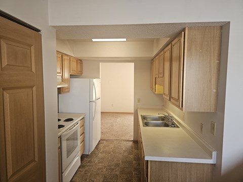 A kitchen with wooden cabinets and a white refrigerator.