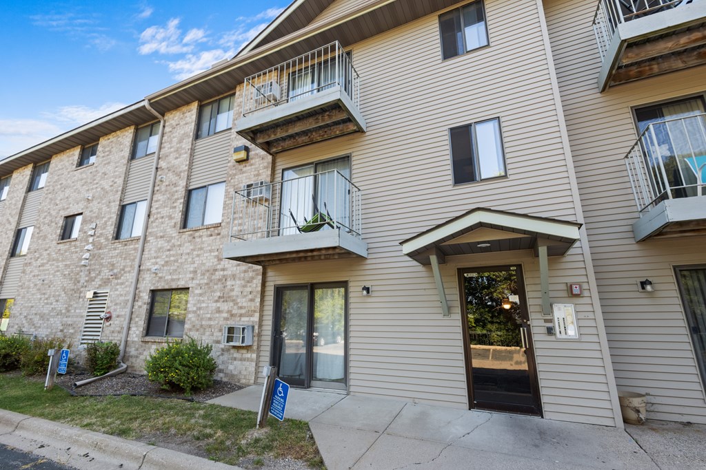 A building with a balcony and a door is shown.