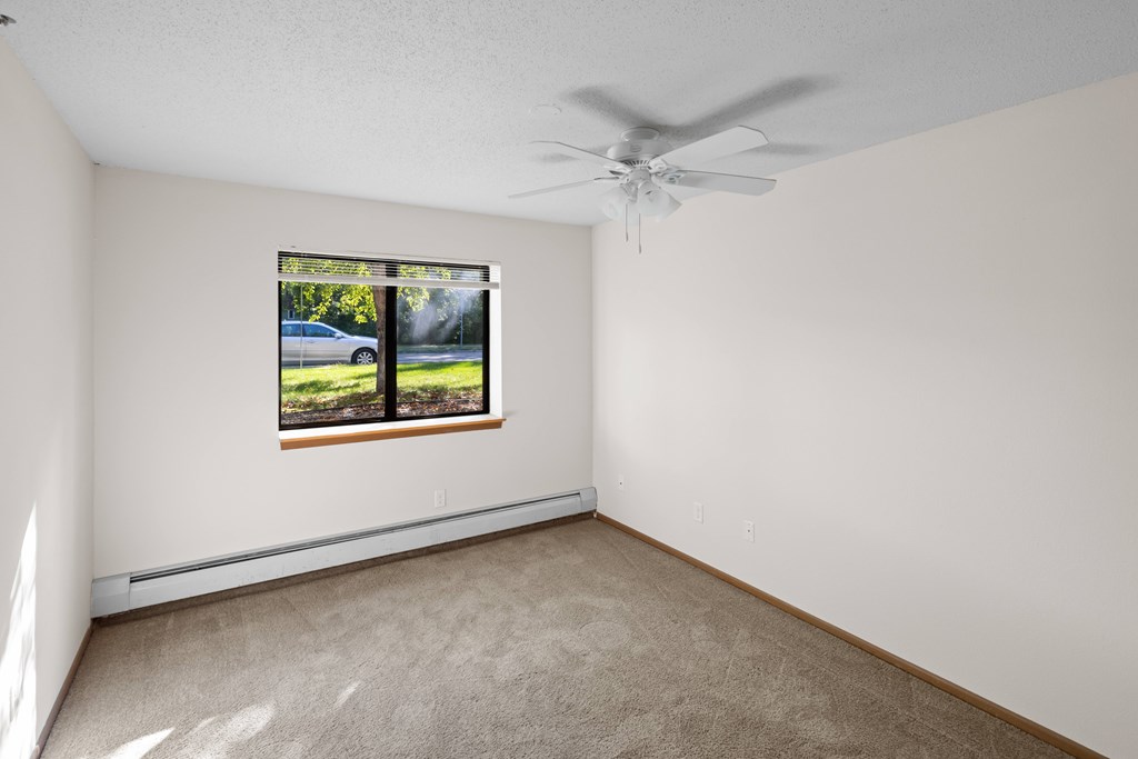 A room with a window and a ceiling fan.