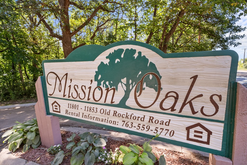 A sign for Mission Oaks with a tree logo and a phone number.