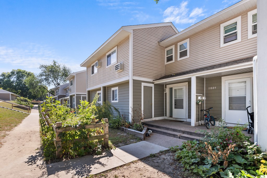 A row of houses with a bicycle leaning against the front door of the first house.