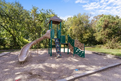 A playground with a slide and a wooden structure.