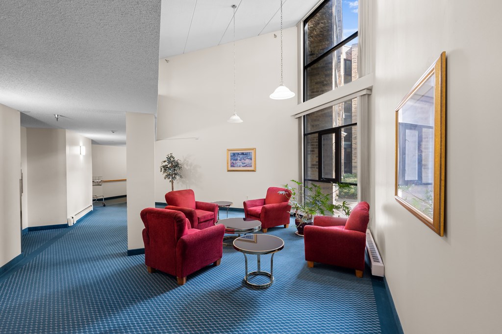 A room with red chairs and a blue carpet.