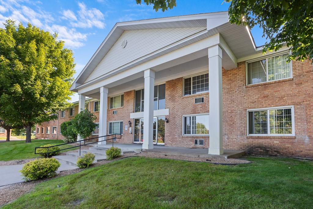 A red brick building with a white roof and a white column.