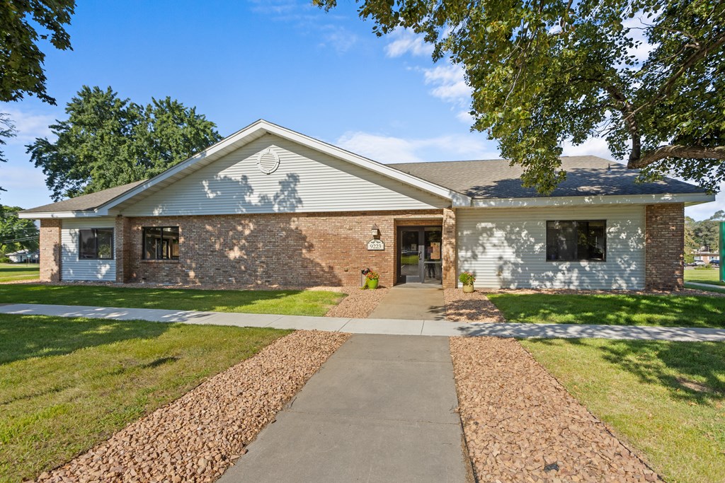 A house with a grey roof and a stone wall.