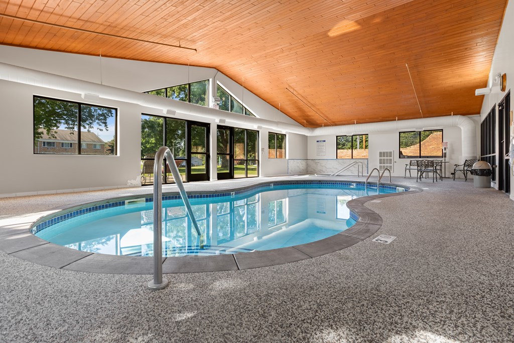 A large indoor swimming pool with a wooden ceiling.