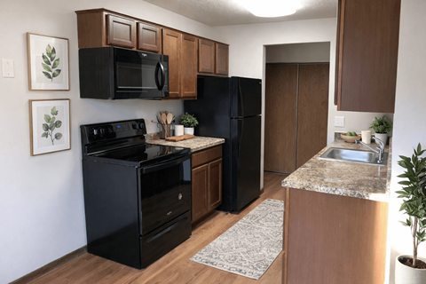 A black oven and microwave in a kitchen with brown cabinets.