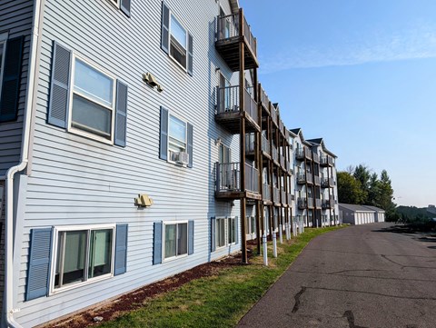 a building with balconies and a street in front of it