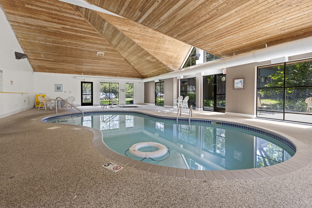 A large indoor swimming pool with a wooden ceiling.