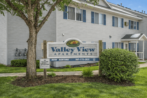 A sign for Valley View Apartments is displayed in front of a building.
